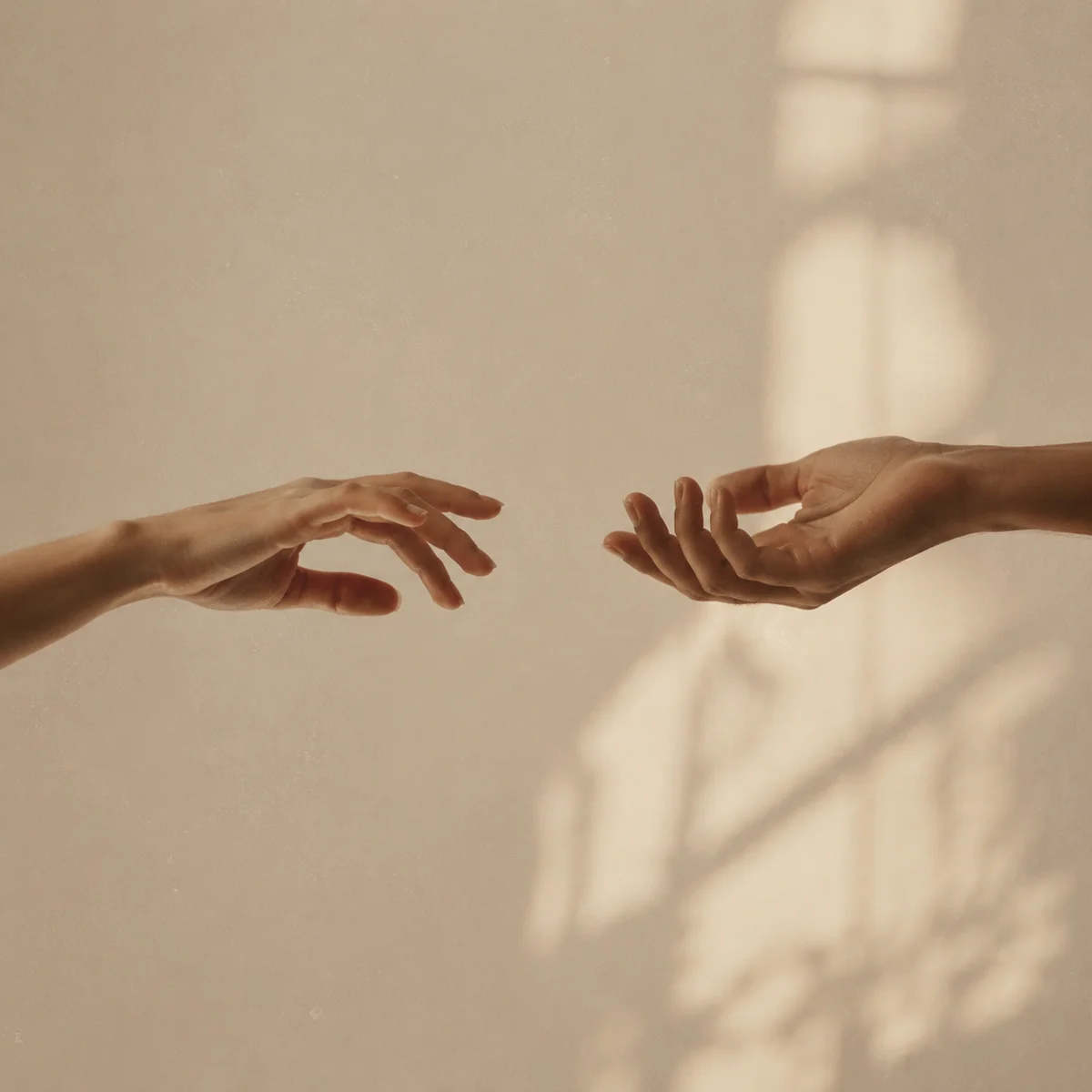 Editorial photo of two hands nearly touching, symbolizing emotional distance after a difficult conversation
