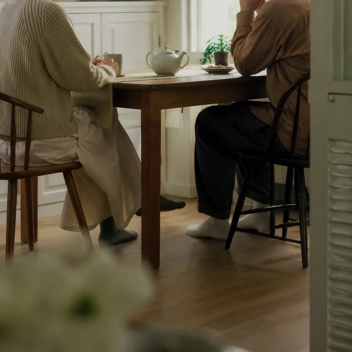 Two people having a calm kitchen conversation about the hotwife lifestyle